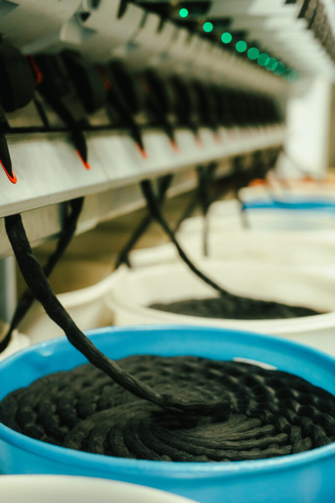 Close-up of fiber slivers being processed into containers for recycling at Coleo
