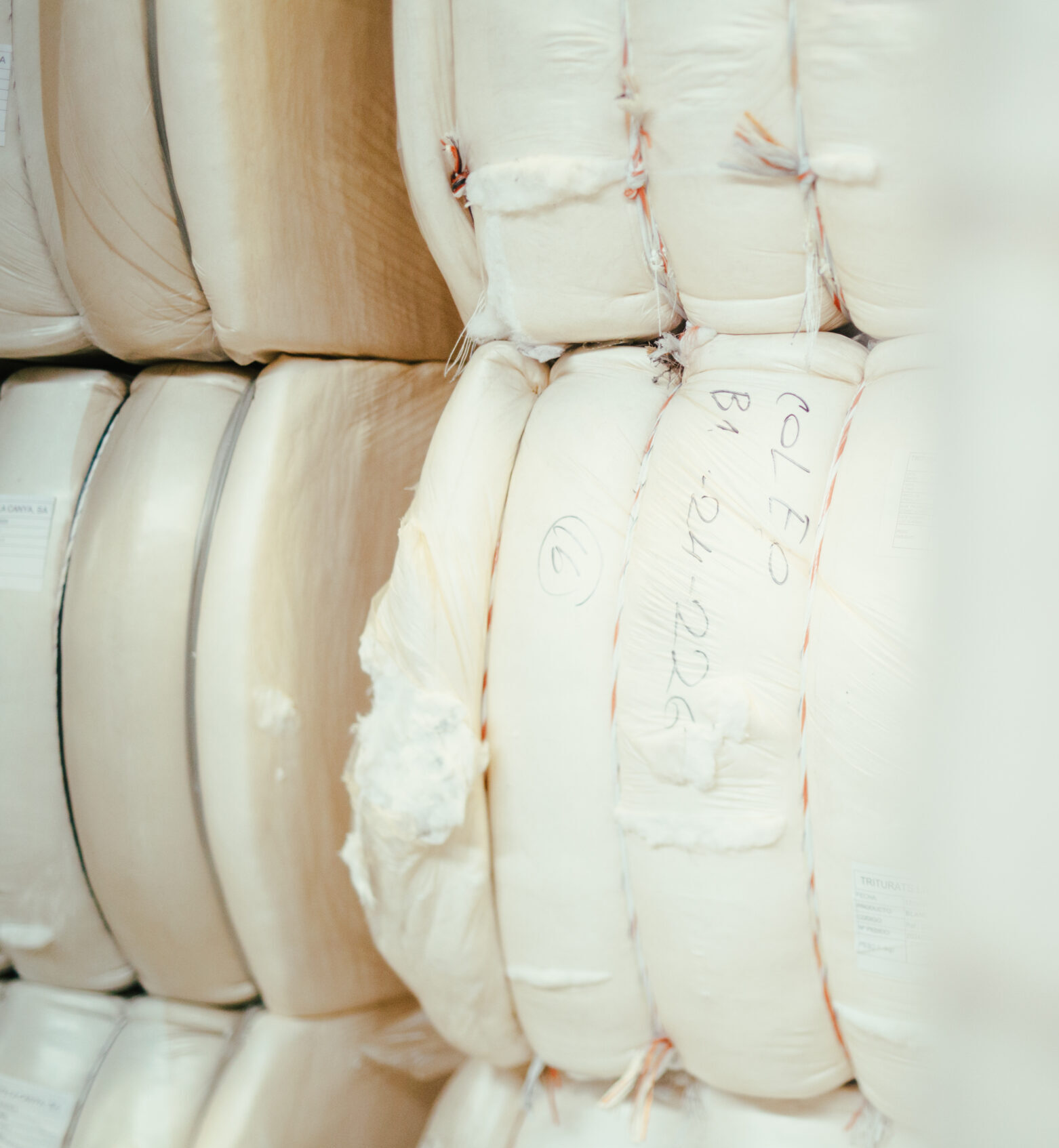 Bales of white recycled fiber prepared for transport at Coleo's facility