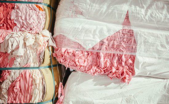 Fardos de residuos textiles rosas reciclados en la planta de Coleo para su reutilización circular